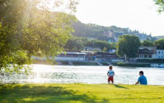 Un padre con su hijo a la orilla del río Elba en Dresde, Alemania. ¿Cuál es el perfil del comprador del seguro de vida en España? Contrata tu seguro de vida riesgo con Segur Torralba.